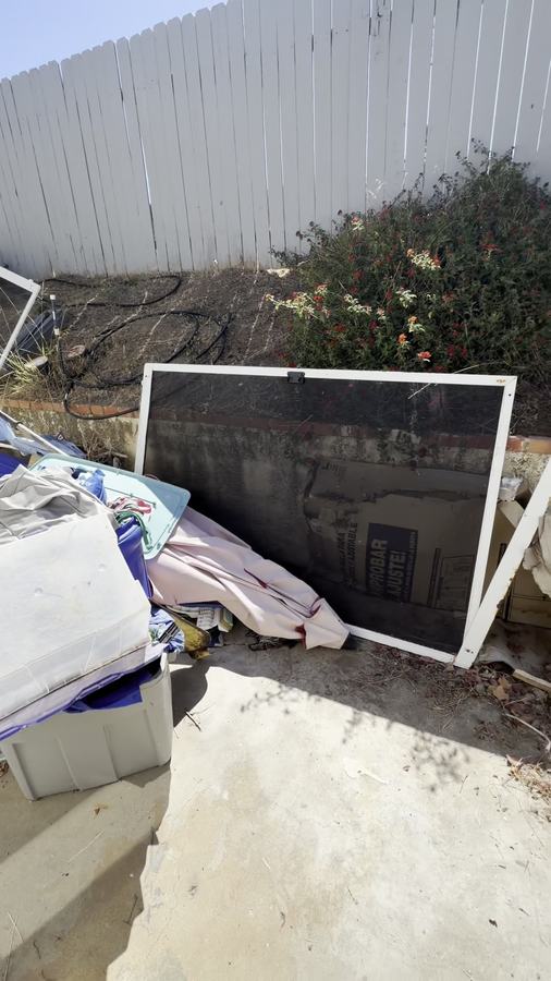 Side-yard cleanout — household debris staged for haul-off